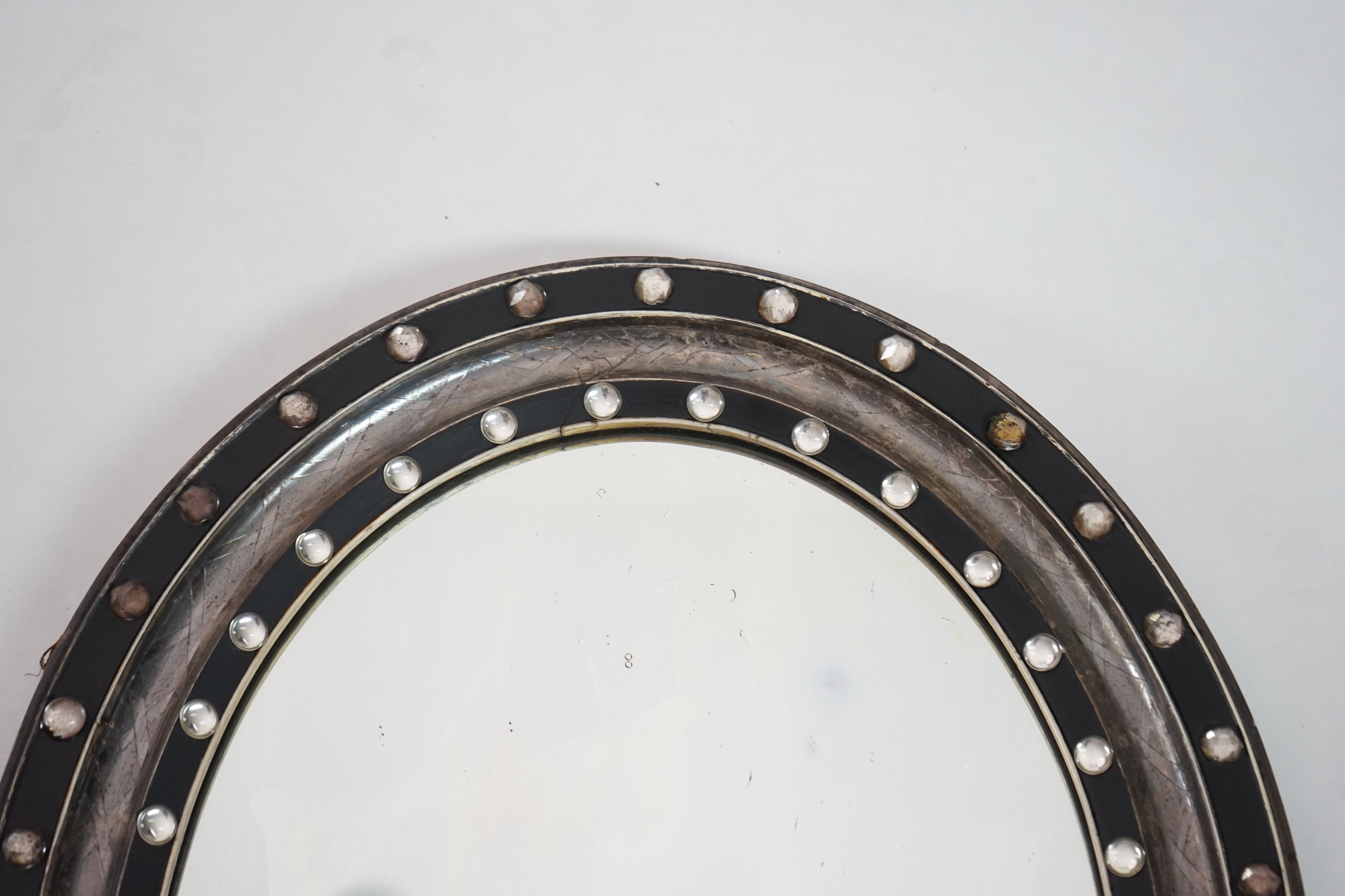 A 19th century Irish ebonised and silvered frame oval wall mirror